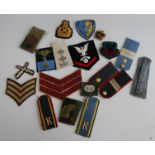 A collection of assorted cloth bullion badges, shoulder boards, rank chevrons etc
