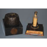 A deactivated shell fuse, on square marble plinth, with inset one penny dated 1918; together with