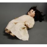 An early 20th century Armand Marseille bisque head doll, rolling blue eyes present but not intact,