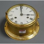 A continental brass cased ships bulkhead clock, the circular enamelled dial with Roman numerals