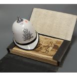 A reproduction police helmet; together with a folio of prints with index card to interior lid
