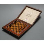 An early 20th century leather cased travelling chess set