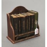 A small Victorian leather clad book trough containing various miniature leather bound books