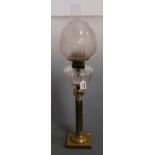 A Victorian oil lamp, having etched glass shade above a clear glass font, raised on a brass