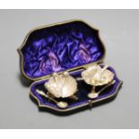 A pair of Victorian white metal open salts, each in the form of a shell, on cast dolphin supports,