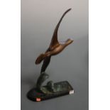 An Art Deco bronzed figure of a bird in flight on a patinated oval base, height 60cm