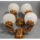 A pair of Art Deco style painted iron twin sconce wall light fittings, with smoky glass shades