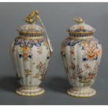 A pair of late 19th century continental faience vases and covers, each of fluted baluster form