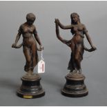 A pair of early 20th century patinated spelter models of female figures each in standing pose on