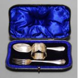 An early 20th century silver three-piece christening set, comprising fork, spoon and napkin ring, in