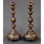 A pair of George V silver and embossed candle sticks on multi knopped stems and domed bases, 16.4oz,