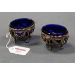 A pair of late 19th century French cast silver table salts with blue glass liners, width 7.2cm