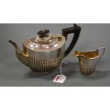 A silver bachelor's teapot together with cream jug, each of half reeded oval form, gross weight 13.