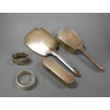 An Art Deco engine turned silver backed part dressing table set comprising hair brush, clothes