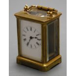 A mid-20th century lacquered brass cased carriage clock, having an enamelled dial with Roman