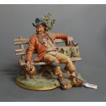 A large Capo di Monte figure of a hobo seated on a bench, having printed mark verso, height 25cm