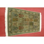 A Persian woven silk rug, having five rows of boxed reserves within multiple trailing tramline