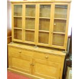 A stained pine round cornered kitchen dresser, having four glazed upper doors, with internal fixed