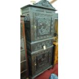 An early 20th century Continental stained and heavily relief carved oak side cupboard, having