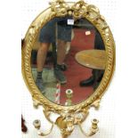 A mid-19th century French giltwood and gesso oval wall mirror, having pierced floral surmount (