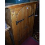 A contemporary stained and planked pine double door side cupboard, having exposed iron hinges, w.