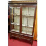 An early 20th century mahogany double door glazed china display cabinet, with twin lower drawers,