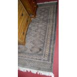A Persian woollen green ground Bokhara rug having trailing tramline borders, 220 x 158cm
