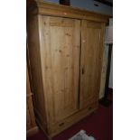 A reclaimed pine double door wardrobe, having single long lower drawer, raised on squat bun