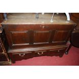 An antique joined oak three panelled hinge topped mule chest, the base with three short lower