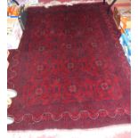 A Turkman woollen red ground rug, the central road medallions within stylised tramline borders,