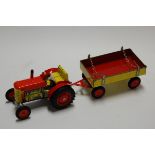 A modern tin plated clockwork model of a tractor with matching trailer