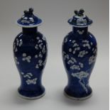 A pair of Chinese export blue and white vases and covers, of baluster form, decorated with prunus