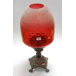 A Victorian and later adapted lamp, having a large bell shaped dimpled cranberry glass shade, on