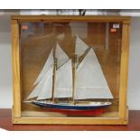 A scratch-built model of a yacht, having full masts and rigging, housed in a glazed pine display