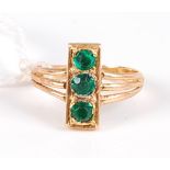 A yellow metal and green hardstone three stone tablet ring, unmarked but tests as approx 20ct, 3.6g,