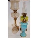 A Victorian oil lamp having a frilled glass shade above a clear glass font on a brass column and