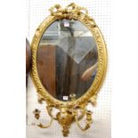 A mid-19th century French giltwood and gesso oval wall mirror, having pierced floral surmount (