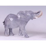 A Royal Copenhagen porcelain model of a standing elephant, with its trunk raised, printed backstamp,