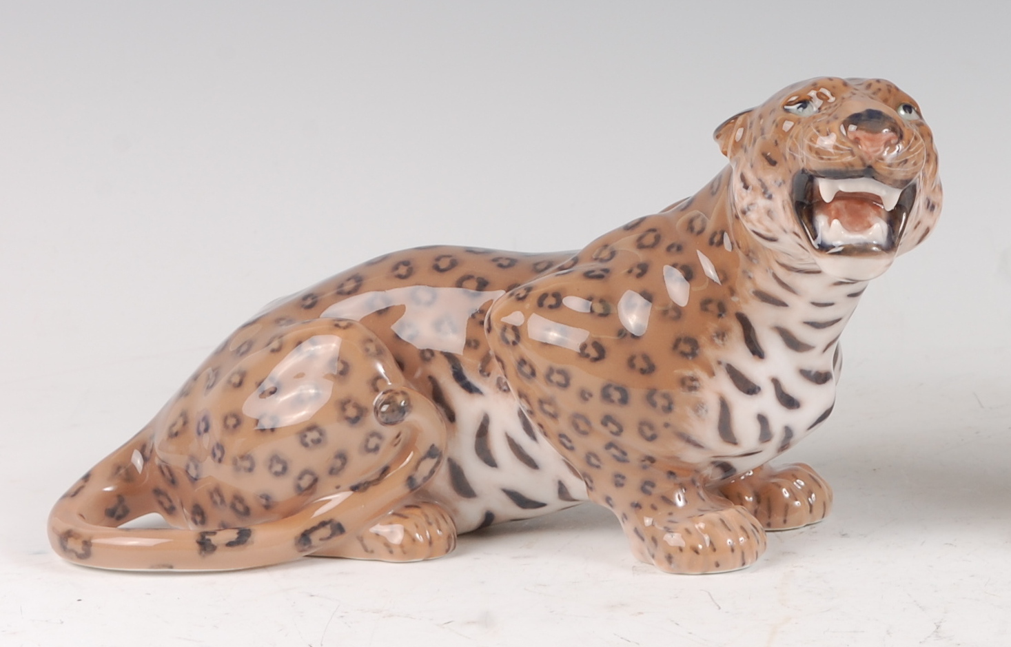 A Royal Copenhagen porcelain model of a Leopard, in perched recumbent pose, printed backstamp and