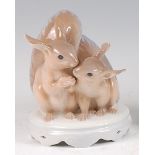 A Royal Copenhagen porcelain model of two long-eared squirrels, each seated, one holding a nut,