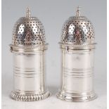 A matched pair of late Victorian silver sugar casters, each of cylindrical form, with finial