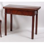 A George III mahogany tea table, having a fold-over top and gateleg action, above a plain frieze,