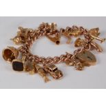 A 9ct gold charm bracelet, having heart shaped padlock clasp and containing a large number of modern