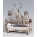 A George III silver seven bottle cruet stand, having a centre carry handle, containing six