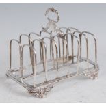 A George IV silver six division toast rack, having foliate embossed loop handle above engraved