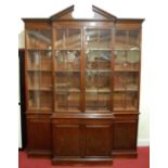 A 19th century mahogany breakfront library bookcase, the broken architectural pediment with dentil