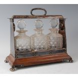 A circa 1900 rosewood and silver plated tantalus, having three hobnail cut bottles and stoppers (