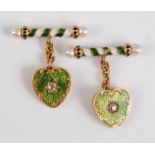 A pair of yellow metal cufflinks, each link comprising a heart shaped plate in green guilloche