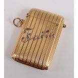 A yellow metal vesta case, the case having a vertical line pattern with the word Faith highlighted