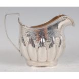 A George IV silver cream jug, of helmet form, having bright cut band of foliate motifs and lobed